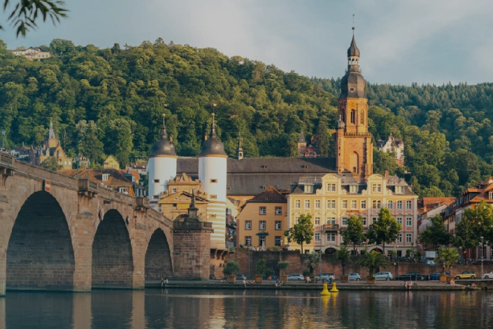 Panorama der Heidelberger Altstadt mit Alter Brücke und Neckar im Vordergrund.