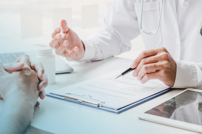 Medizinische Fachperson im Patientengespräch am Schreibtisch, im Kontext der aktualisierten ESE-Guideline zum chronischen Hypoparathyreoidismus